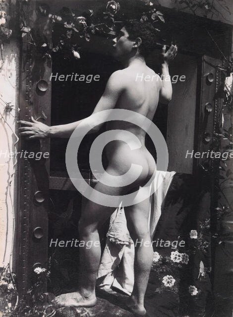 A Sicilian male, posing naked outdoors, by a doorway, c1900. Creator: Guglielmo Pluschow.