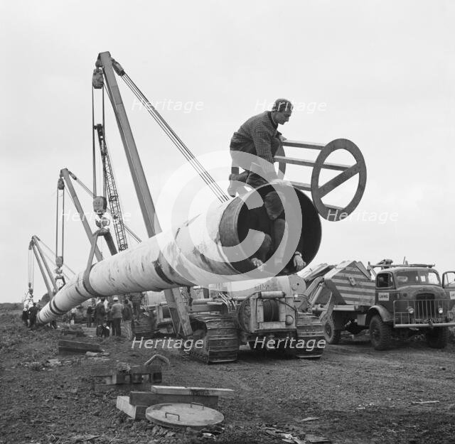 The Fens gas pipeline being lifted by a row of Caterpillar 583 pipelayers, Norfolk, 20/09/1967. Creator: John Laing plc.