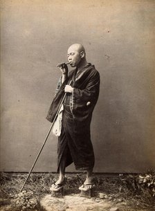 A blind Japanese masseur with a pipe in his mouth and a long pole in his hand, c1890s. Creator: Unknown.