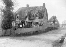 Thatched cottage with its inhabitants standing outside, Ramsbury, Wiltshire, c1860-c1922. Artist: Henry Taunt