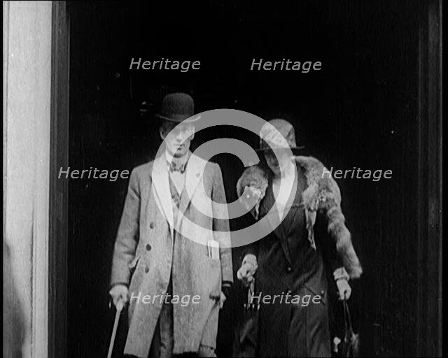 A Male Civilian and Female Civilian Emerging from a Building, 1924. Creator: British Pathe Ltd.