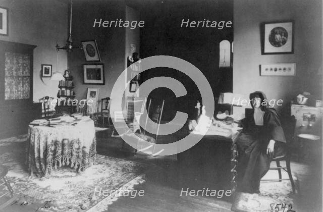 Georgetown Convent, Washington, D.C. - nun seated at desk in furnished room, not after 1892. Creator: Frances Benjamin Johnston.