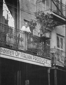 Woman leaning on a balcony, New Orleans, between 1920 and 1926. Creator: Arnold Genthe.