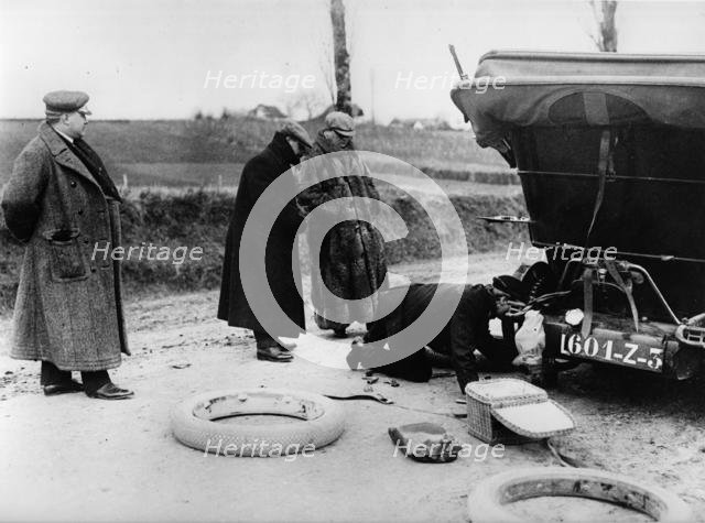 Wheel change by chauffeur on Lord Northcliffe's 1908 Mercedes. Creator: Unknown.