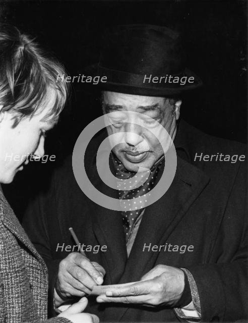 Duke Ellington signing his autograph, c1962. Creator: Brian Foskett.