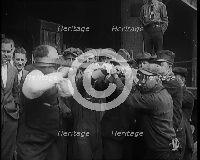 A Male Stuntman Bending Iron Bars Around His Head, 1926. Creator: British Pathe Ltd.
