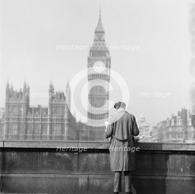Houses of Parliament seen from the Albert Embankment with a man reading..., London, 1964. Creator: John Gay.