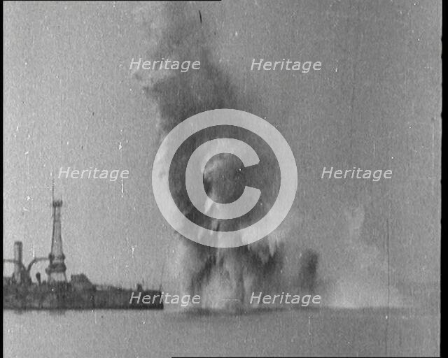 Bombs Dropped from Planes Exploding near a Warship, 1922. Creator: British Pathe Ltd.