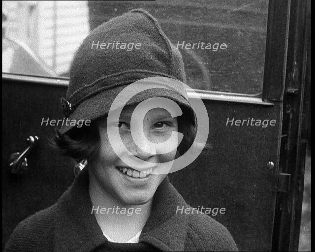 A Young Female American Civilian Being Rescued from Kidnapping Smiling at the Camera, 1930. Creator: British Pathe Ltd.