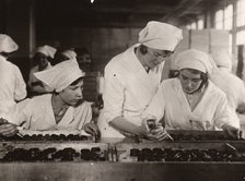 A girl is taught how to hand-pipe chocolates, Rowntree factory, York, Yorkshire, 1933. Artist: Unknown