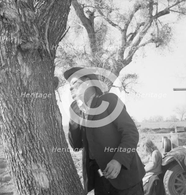 Migrant man shaving by roadside, on U.S. 99 between Bakersfield and the Ridge, 1939. Creator: Dorothea Lange.