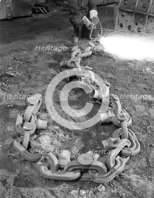 Cutting off lead from a manganese chain casting, Sheffield, South Yorkshire, 1965. Artist: Michael Walters