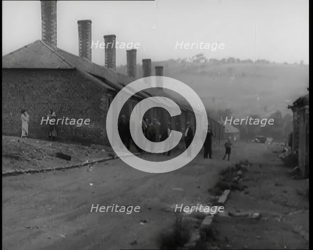 Male Civilians Standing in the Streets Outside of Their Houses, 1926. Creator: British Pathe Ltd.
