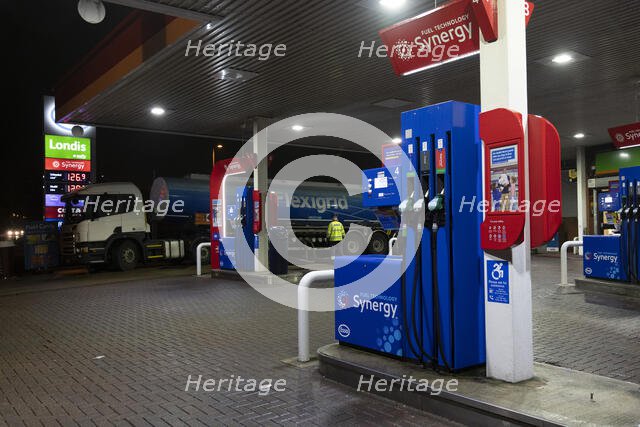 Esso petrol station forecourt with tanker delivering fuel, 2020. Creator: Tim Woodcock.