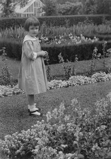 Truesdale, Virginia, Miss, standing in a garden, 1915 July 21. Creator: Arnold Genthe.