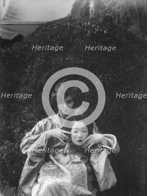 Person holding a mask made by W.T. Benda, 1925 Sept. 20. Creator: Arnold Genthe.