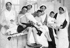 Wounded children from Ypres with nurses at La Panne, Belgium, First World War, 1914-1918, (c1920). Artist: Unknown