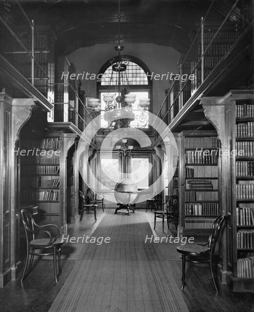 Shelves in library, U.S. Naval Academy, between 1890 and 1901. Creator: Unknown.