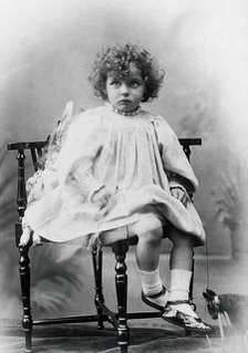 Nora Schuster aged 3, seated, facing forwards, c1895. Creator: Mrs Fred Wilkinson.