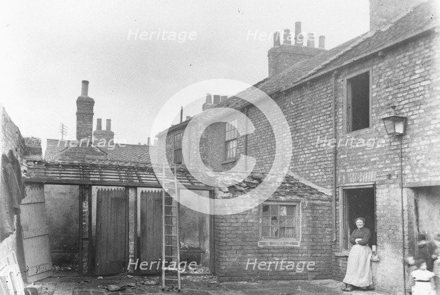 A woman stands in the back yard of a house, York, Yorkshire, 1923. Artist: Unknown