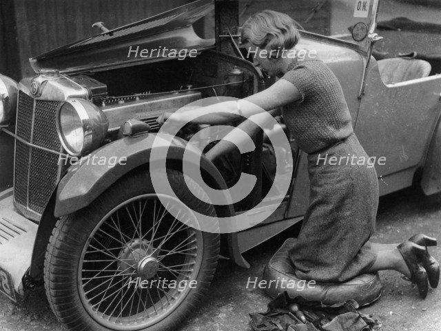 Kitty Brunell working on her MG F Magna. Artist: Unknown