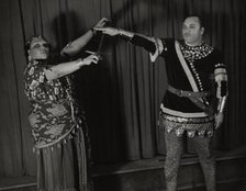 Minto Cato as Azucena and Parker Watkins as Manrico, swearing vengeance on a sword, 1936. Creator: Eagle Ezzes & Mipaas.