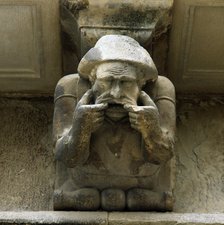 Façade of the Paeria of Cervera, anthropomorphic corbel of a personage sick of the teeth showing …