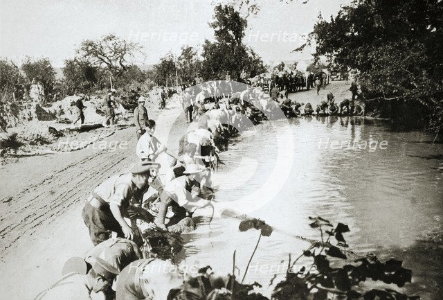 Transport men cleaning their harness at a pond after wet weather, France, World War I, 1916. Artist: Unknown
