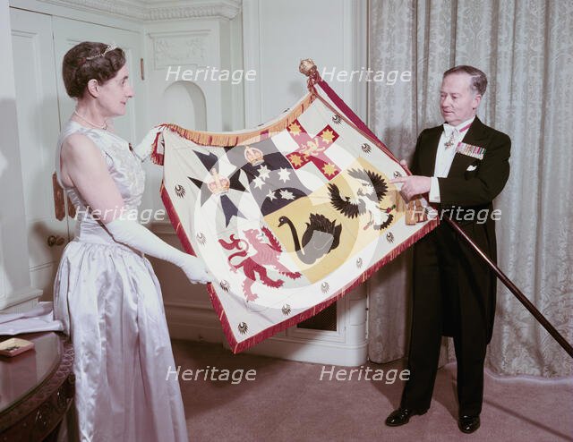 The Australian High Commissioner to Britain and his wife holding the standard of Australia, 1953. Creator: Arthur Charles Kirby Ware.