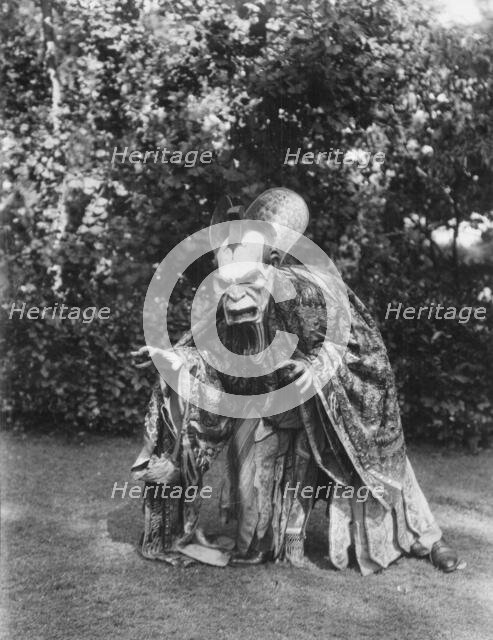 Person wearing a mask made by W.T. Benda, 1925 Sept. 20. Creator: Arnold Genthe.