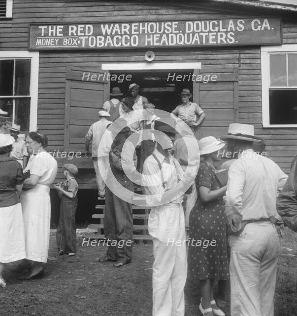As the auctioneer knocks down the last bid on each basket of tobacco..., Douglas, Georgia, 1938. Creator: Dorothea Lange.