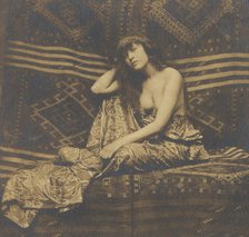 Portrait of a woman, partially draped, seated on a sofa, 1900. Creator: Unknown.