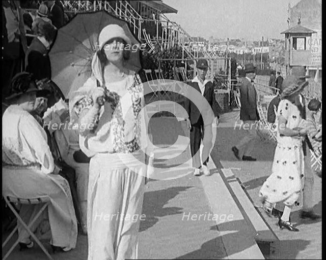 Female Civilian Wearing Smart outfit and Hat Holding a Parasol Walking Towards the Camera..., 1920. Creator: British Pathe Ltd.