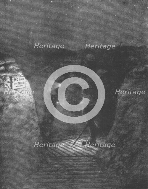 ''Une tournee d'inspectionnocturne dans les boyaux, a la lueur discrete des lampes de poche.', 1916. Creator: Unknown.