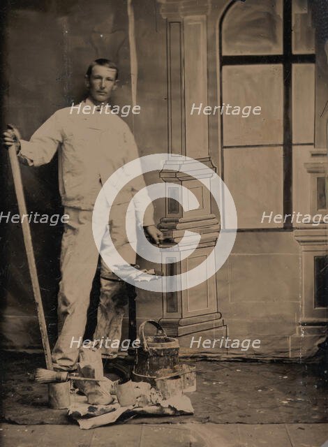[Painter, Standing in Front of a Painted Window Backdrop, with Brushes, Bucket, and P..., 1870s-80s. Creator: Unknown.
