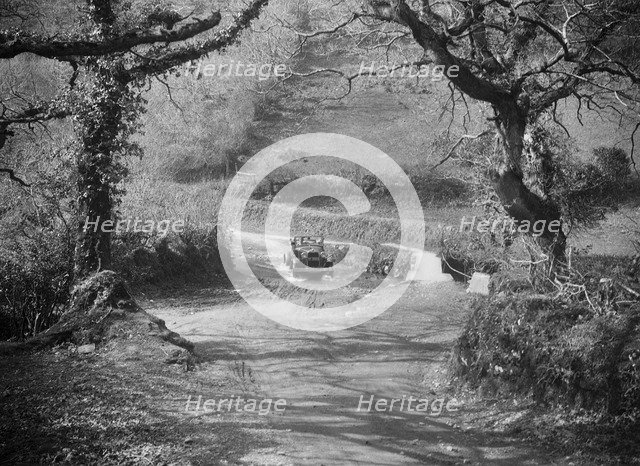 Kitty Brunell driving a 1930 Ford Model A 2-seater through a ford, 1931. Artist: Bill Brunell.