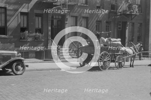 A tenant is moving on horse-drawn wagon, 61st Street between 1st and 3rd Avenues, New York, 1938. Creator: Walker Evans.
