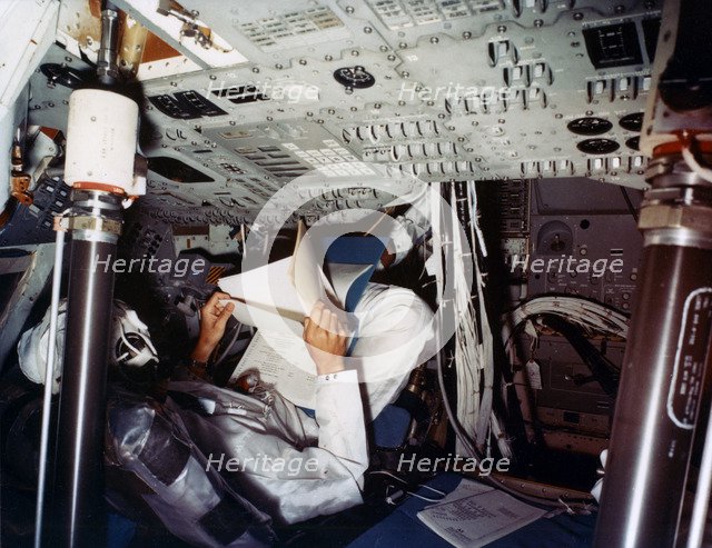 An astronaut inside a NASA Command Module, 1970s.Artist: NASA