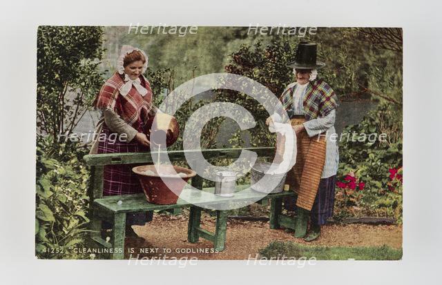 "Cleanliness is next to Godliness".  Women in Welsh costume washing in tubs on bench, c1900s Creator: Unknown.