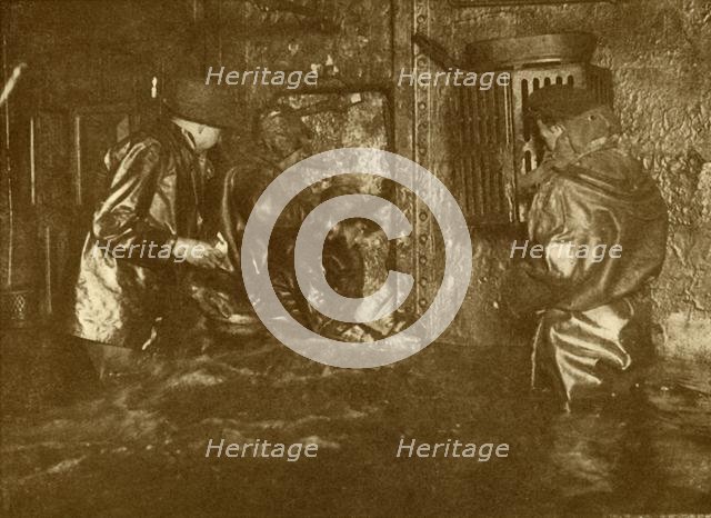 'Divers Plugging A Leak During Salvage Operations Waist-Deep In Water On the Lower Decks Of The Germ Creator: Unknown.