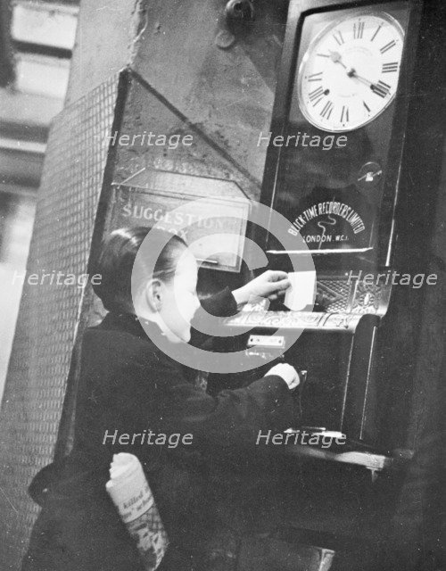 Young boy clocking on at the Trocadero Restaurant, Leicester Square, Westminster, London, c1939. Artist: Unknown