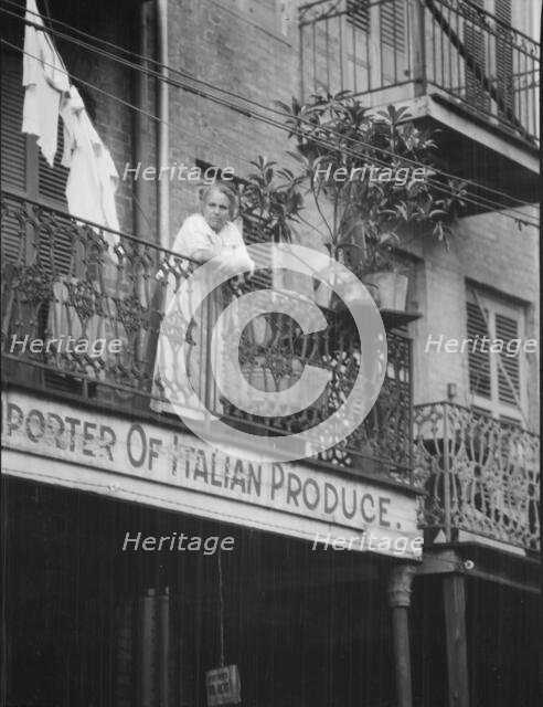 Woman leaning on a balcony, New Orleans, between 1920 and 1926. Creator: Arnold Genthe.