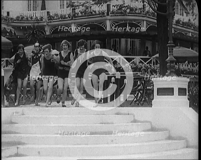 A Group of Young Female Civilians Running down Some Steps Wearing Swimsuits, 1920. Creator: British Pathe Ltd.
