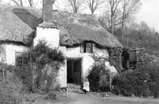 A girl sitting outside a thatched cottage, Minehead, Somerset, c1900. Artist: Farnham Maxwell Lyte