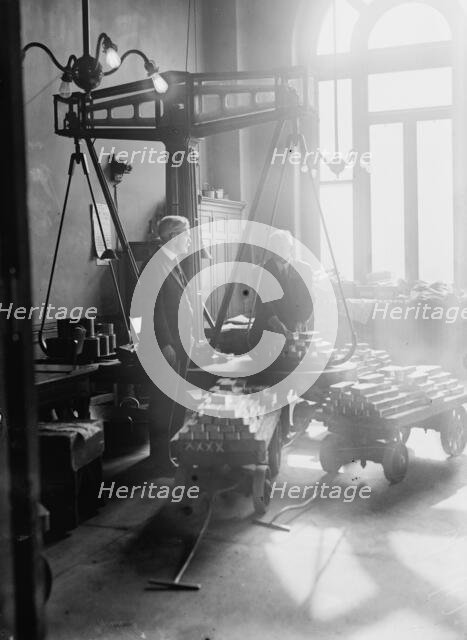 Weighing gold, U.S. Mint, 1917. Creator: Bain News Service.