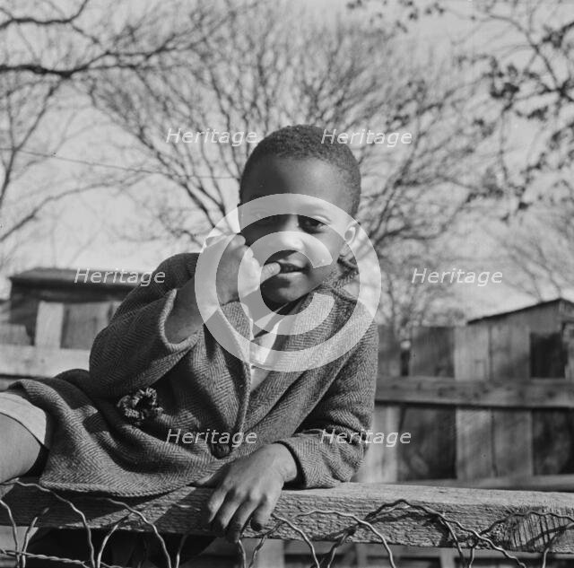 Boy playing on a fence, Washington (southwest section), D.C., 1942. Creator: Gordon Parks.