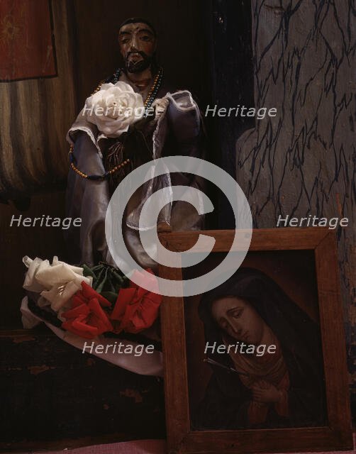 A Santo bulto and a painting of the Dolorosa in the church, Trampas, New Mexico, 1943. Creator: John Collier.