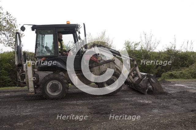 Road resurfacing work repairing potholes Artist: Unknown.