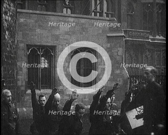 British Fascists Kneeling and Saluting in London. Some Are Carrying Flags, 1922. Creator: British Pathe Ltd.
