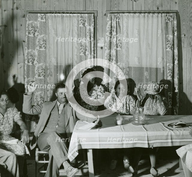 African American men and women sitting in attendance at a meeting to discuss farm..., May 1940. Creator: Farm Security Administration.
